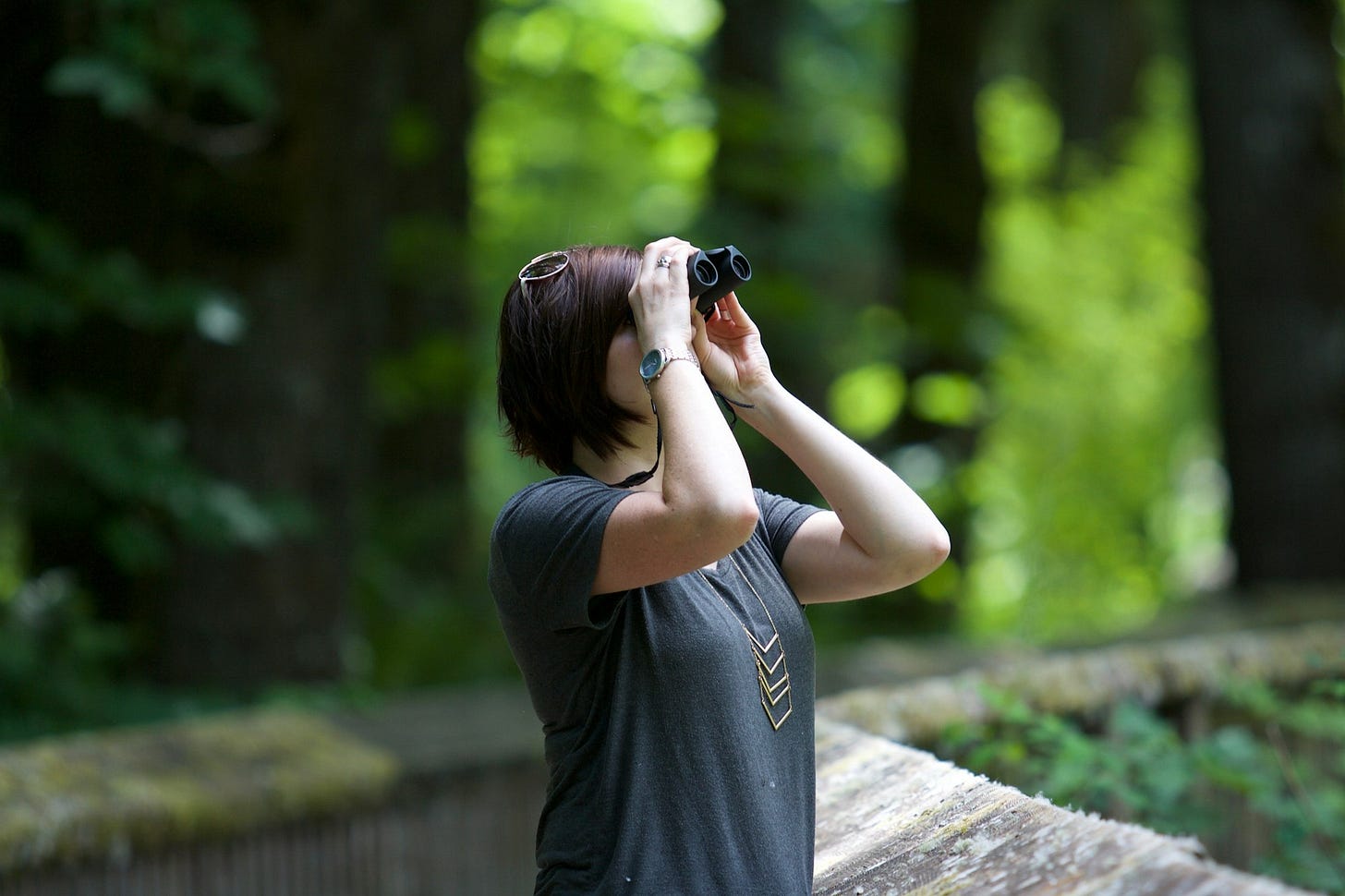 selective photography of woman holding binoculars looking upward outdoors selective photography of woman holding binoculars looking upward outdoors