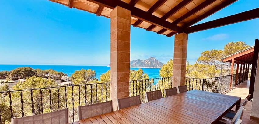 A table and chairs on a porch overlooking the ocean

AI-generated content may be incorrect.