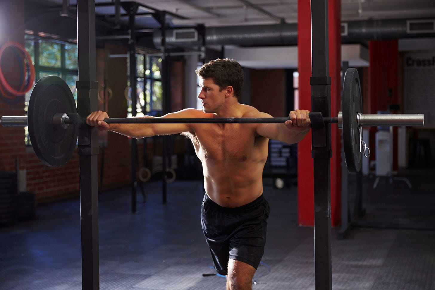 Man gripping barbell on weightlifting equipment