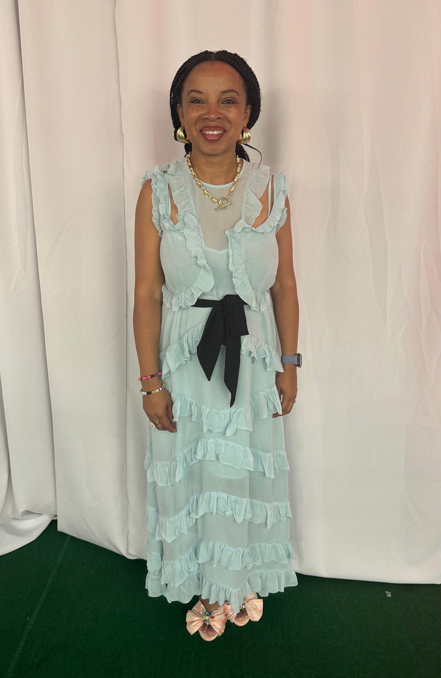 Natalie Lue wearing light blue Sienna Miller X M&S dress at a wedding with black belt and Louboutin heels. 