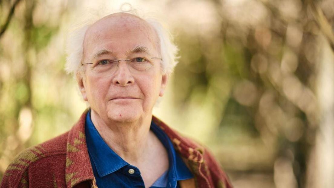Phillip Pullman, wearing a blue shirt and burgundy jacket
