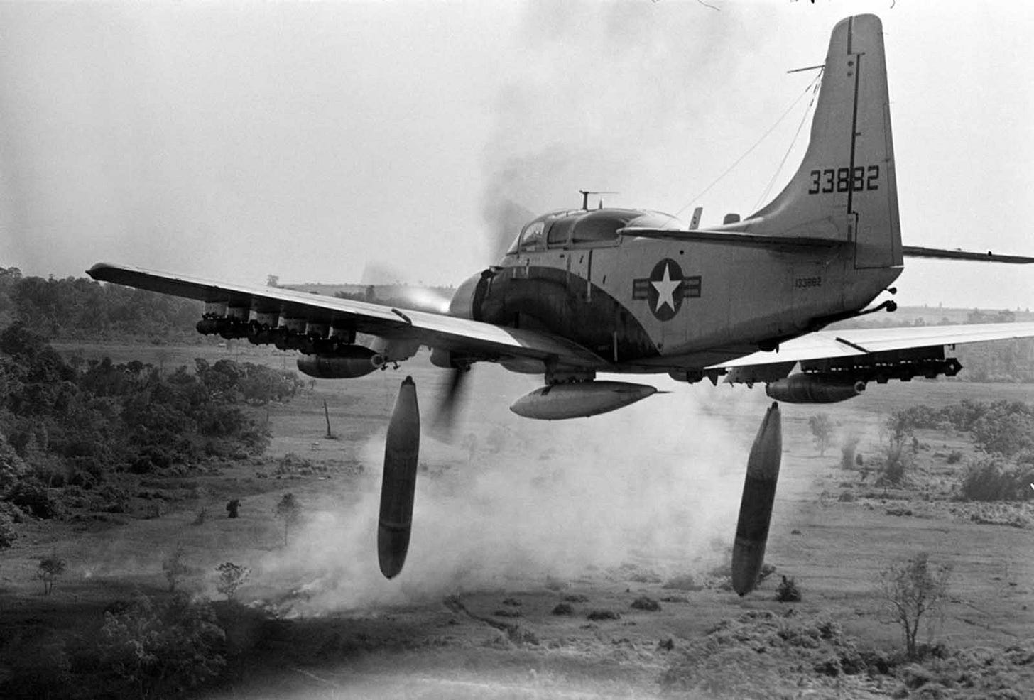 An A-1 Skyraider fighter-bomber unleashes 500-pound bombs on a Viet Cong position in the dense jungle, as smoke from an earlier strike billows, December 26, 1964. An A-1 Skyraider fighter-bomber unleashes 500-pound bombs on a Viet Cong position in the dense jungle, as smoke from an earlier strike billows, December 26, 1964.