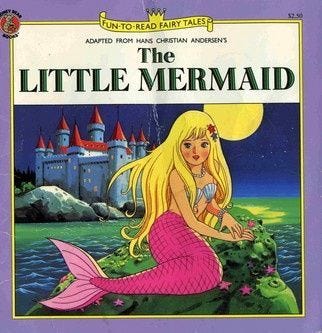 This may contain: the little mermaid is sitting on top of a rock This may contain: the little mermaid is sitting on top of a rock