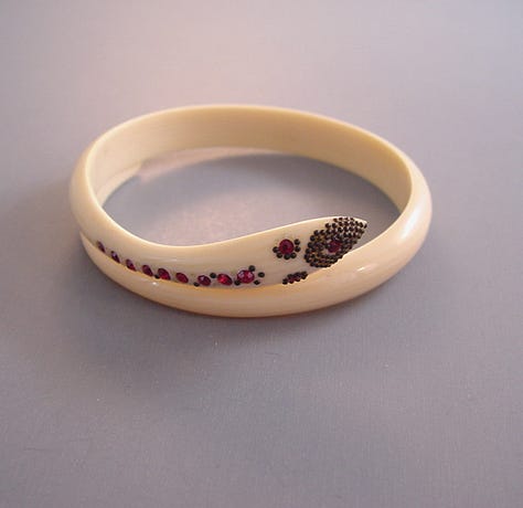 Stylized snake forms beginning in horn or shell are remade in early plastic approximations of natural materials.