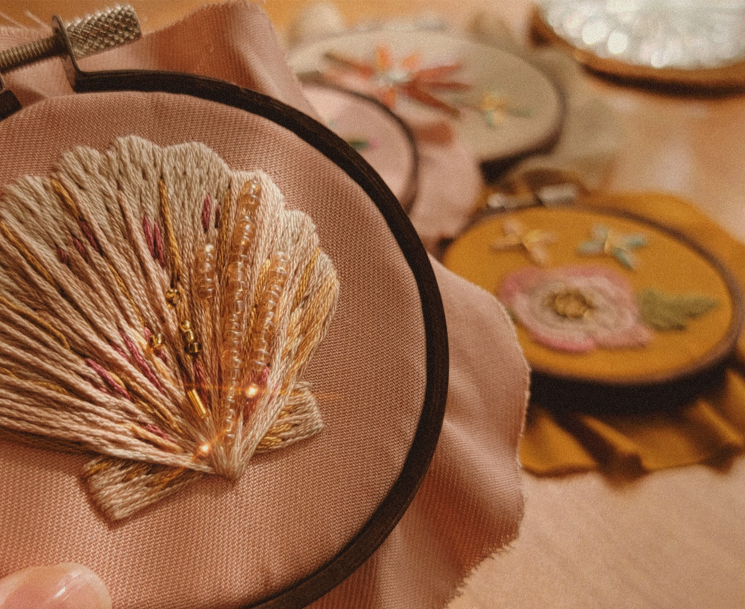 close-up of a seashell embroidery with several other embroideries scattered in the background close-up of a seashell embroidery with several other embroideries scattered in the background