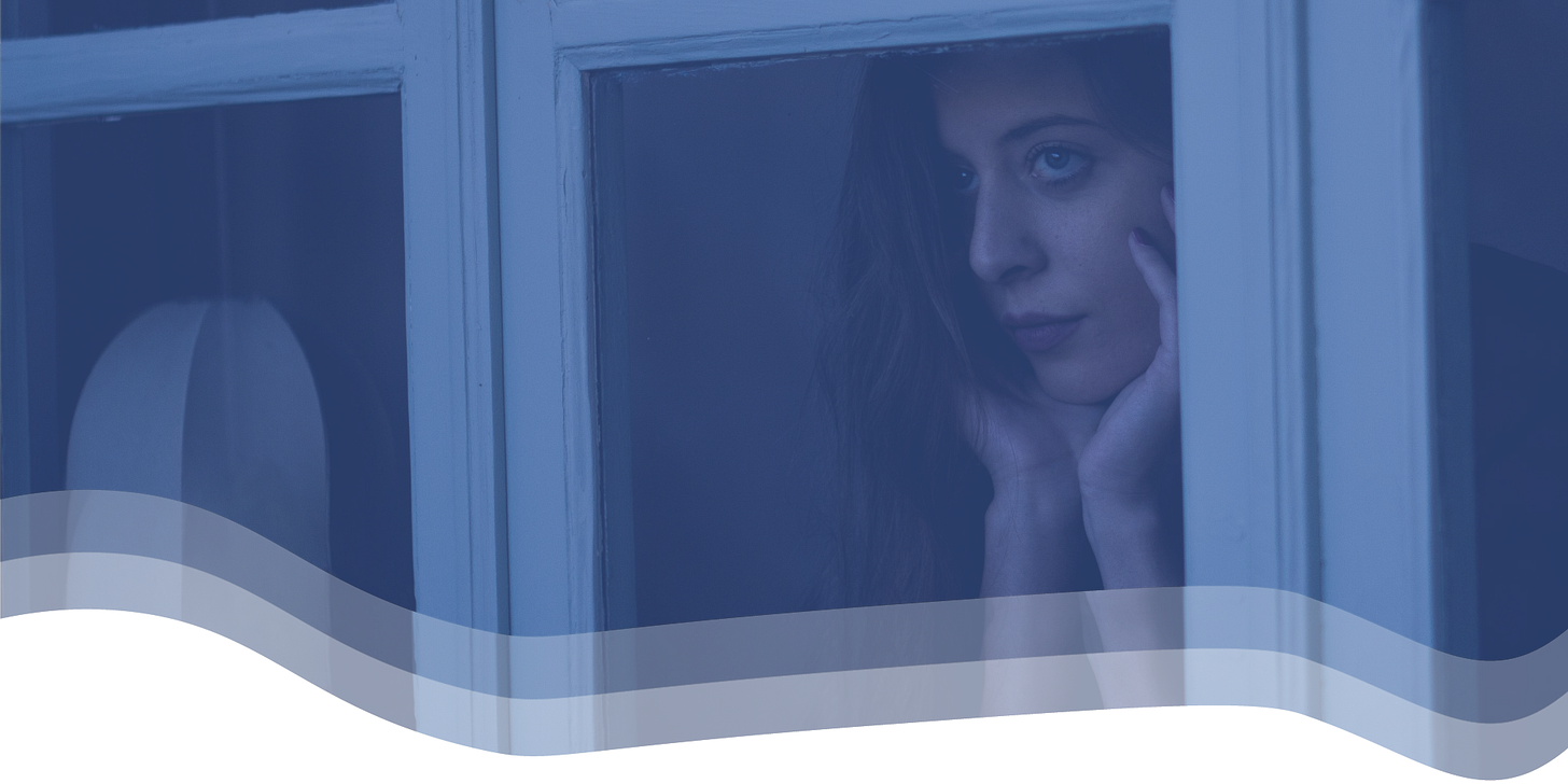 A woman gazes sadly out a window.