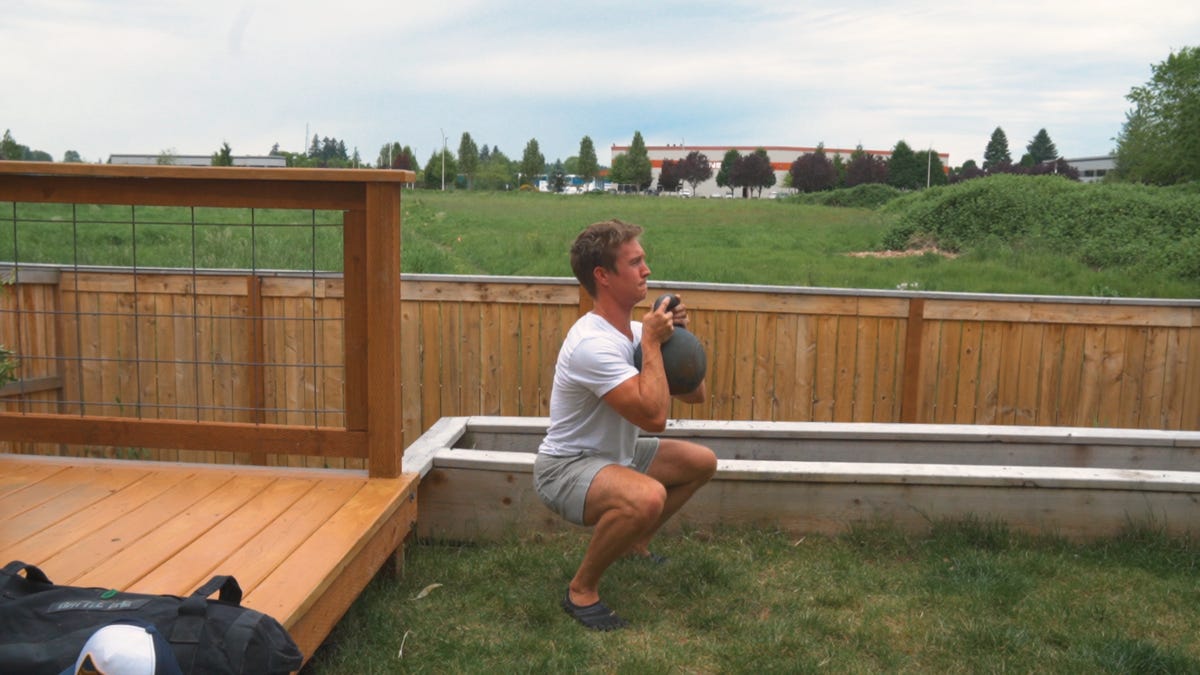 goblet squats holding a kettle bell