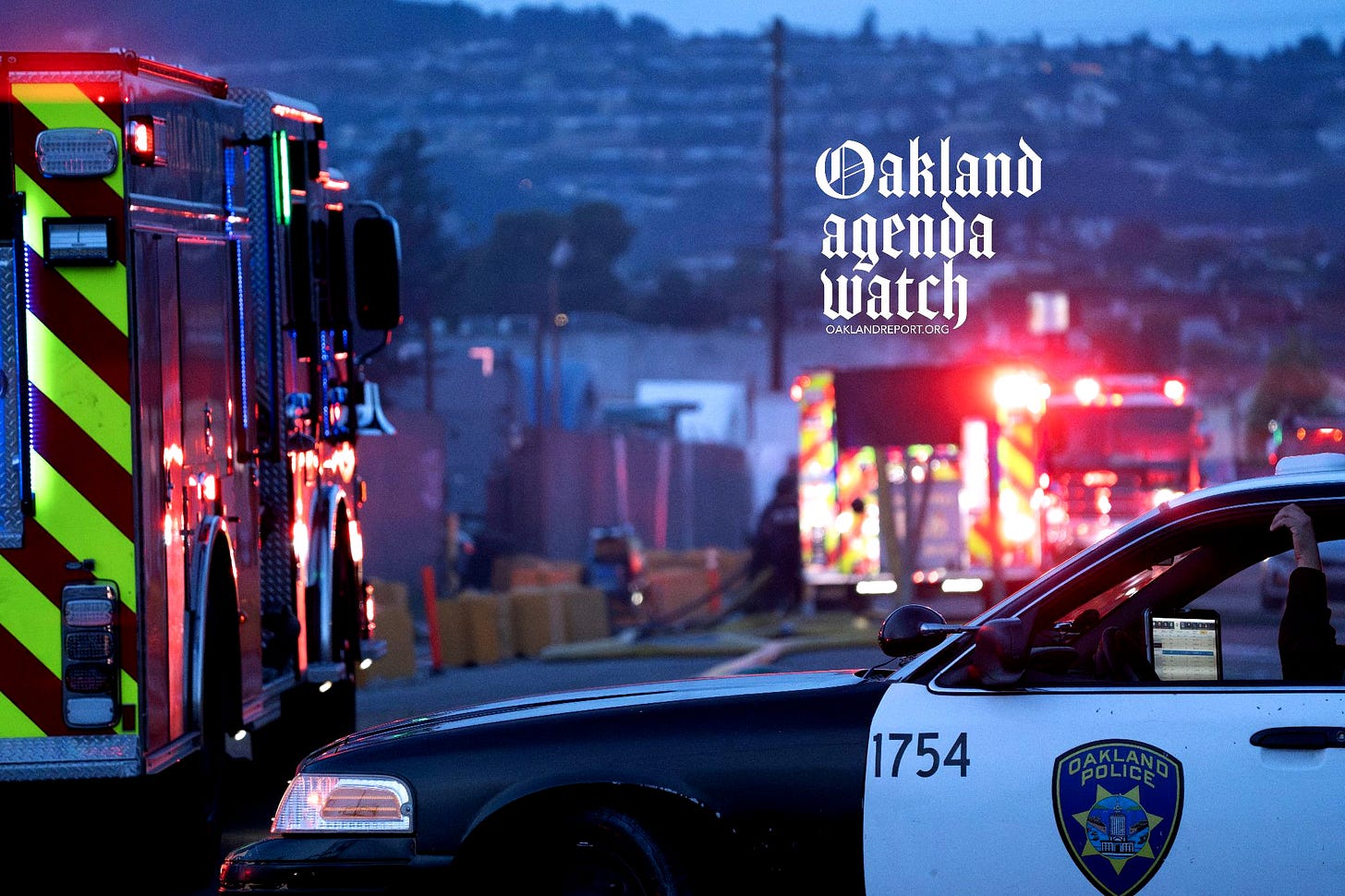 A police car and fire trucks parked outside a blaze at a transfer station in East Oakland on Apr. 28, 2026. Two RVs caught fire in the enclosed lot. (Photo: Shutterstock / Oakland Report) A police car and fire trucks parked outside a blaze at a transfer station in East Oakland on Apr. 28, 2026. Two RVs caught fire in the enclosed lot. (Photo: Shutterstock / Oakland Report)