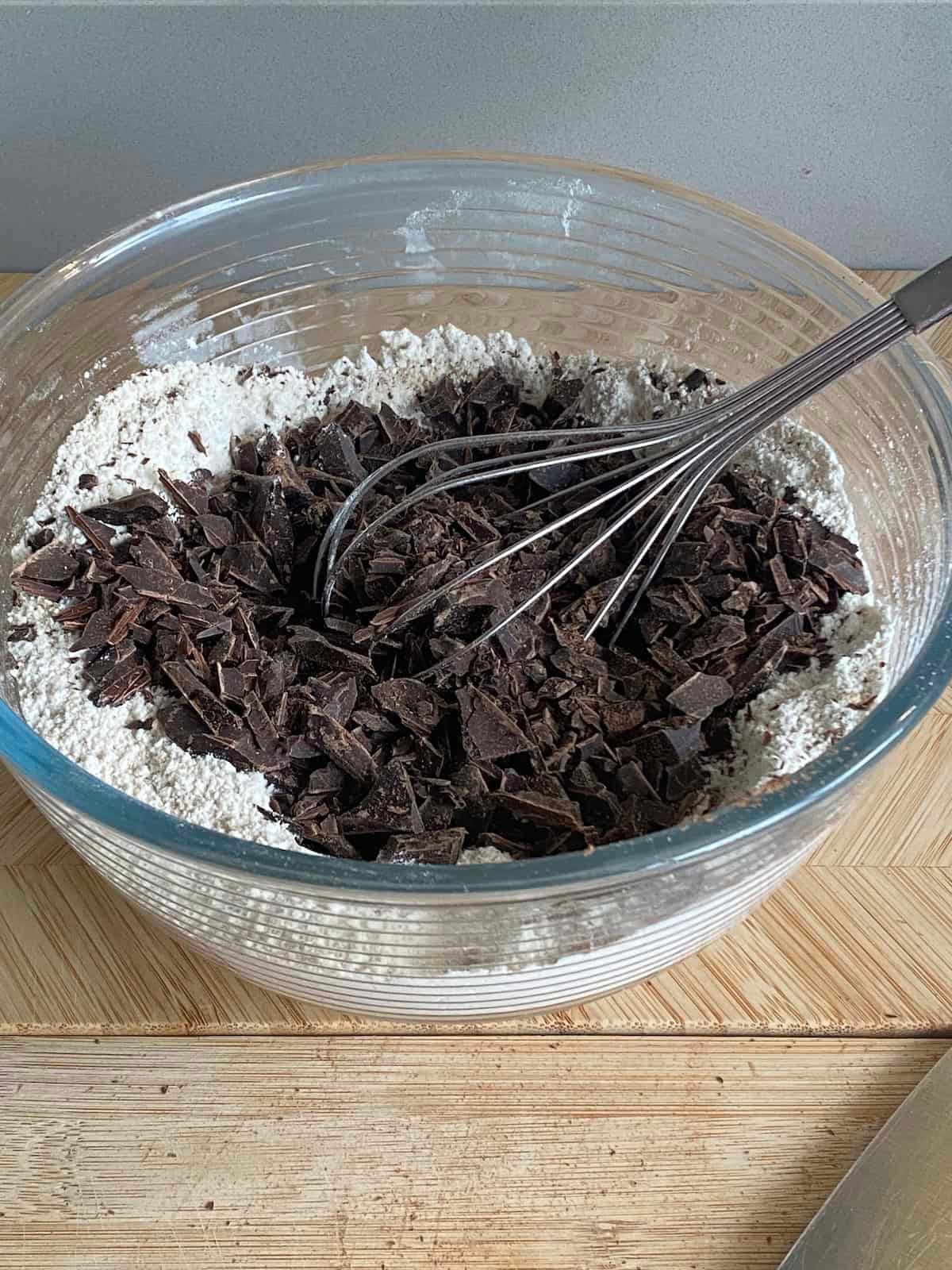 Mixing chocolate chunks with flour. Mixing chocolate chunks with flour.
