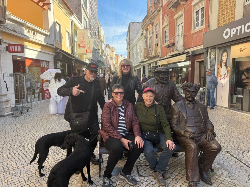 People sat on bench with statues and labradors People sat on bench with statues and labradors