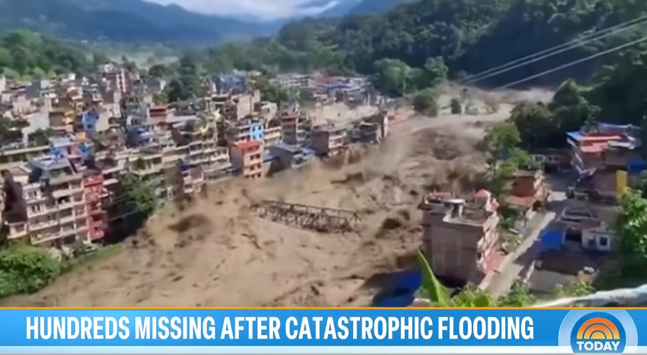 Video screenshot showing a steel-truss bridge being swept away by a flooded river; moments later, entire multi-story buildings collapsed into the torrent. Today Show chyron reads 'hundreds missing after catastrophic flooding.' Video screenshot showing a steel-truss bridge being swept away by a flooded river; moments later, entire multi-story buildings collapsed into the torrent. Today Show chyron reads 'hundreds missing after catastrophic flooding.'
