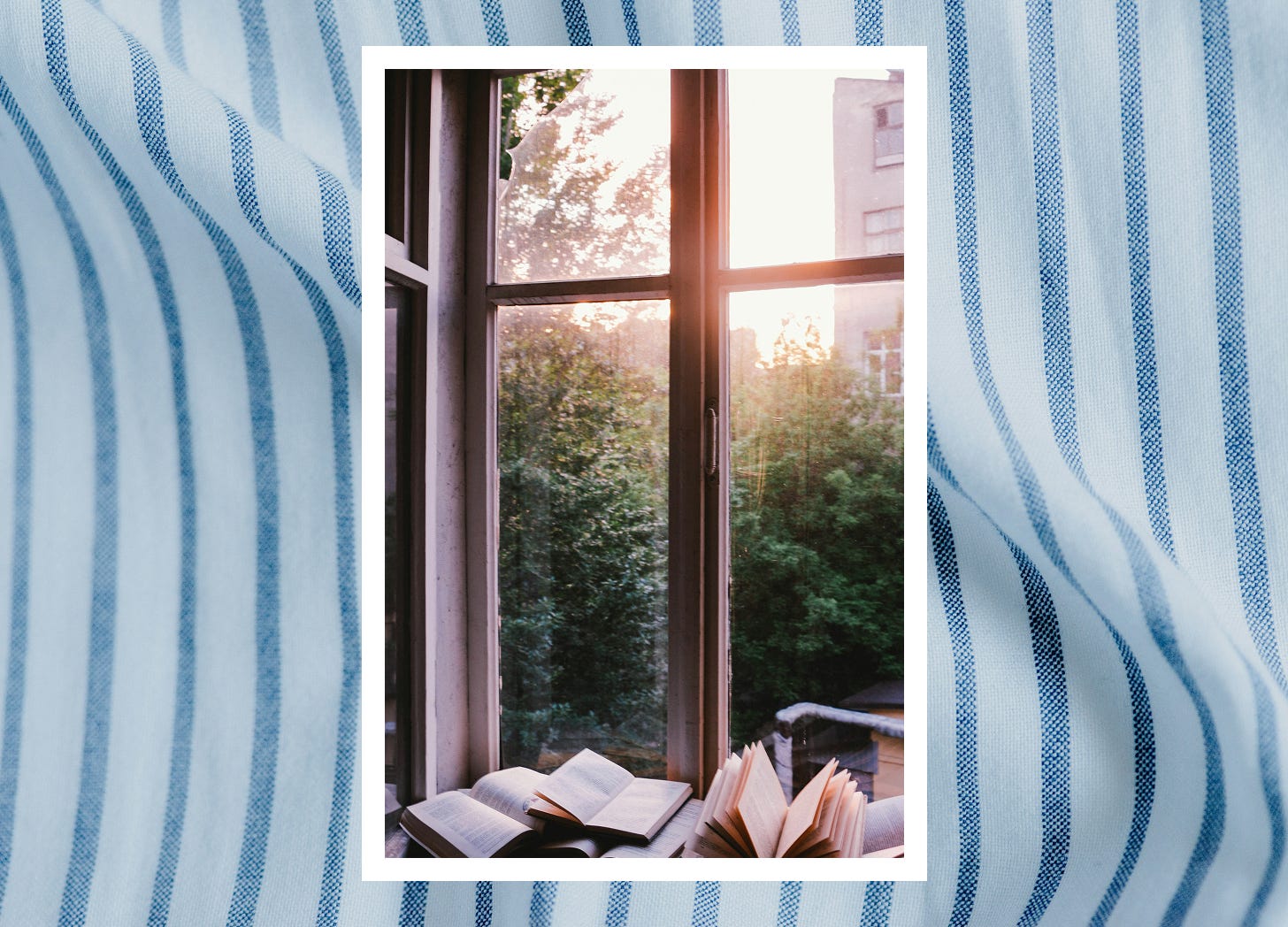 A photograph of a window with light streaming in and books at its base, placed against a blue striped linen fabric background A photograph of a window with light streaming in and books at its base, placed against a blue striped linen fabric background