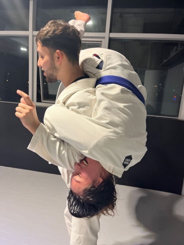 This may contain: a man doing a handstand on another man's head