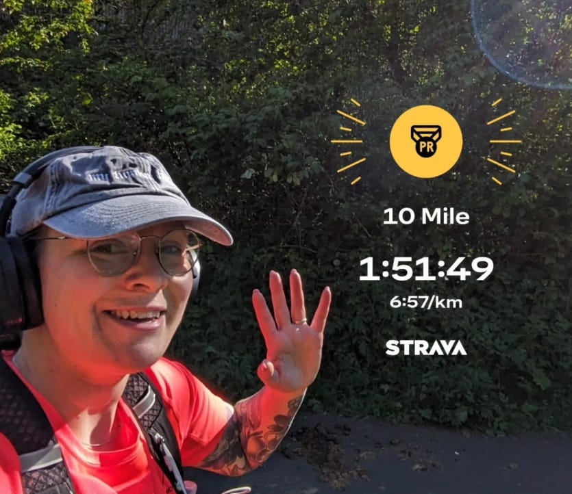 Selfie of Ellen mid-run, waving at the camera, with text overlay of her 10 mile time and a little yellow medal symbol.