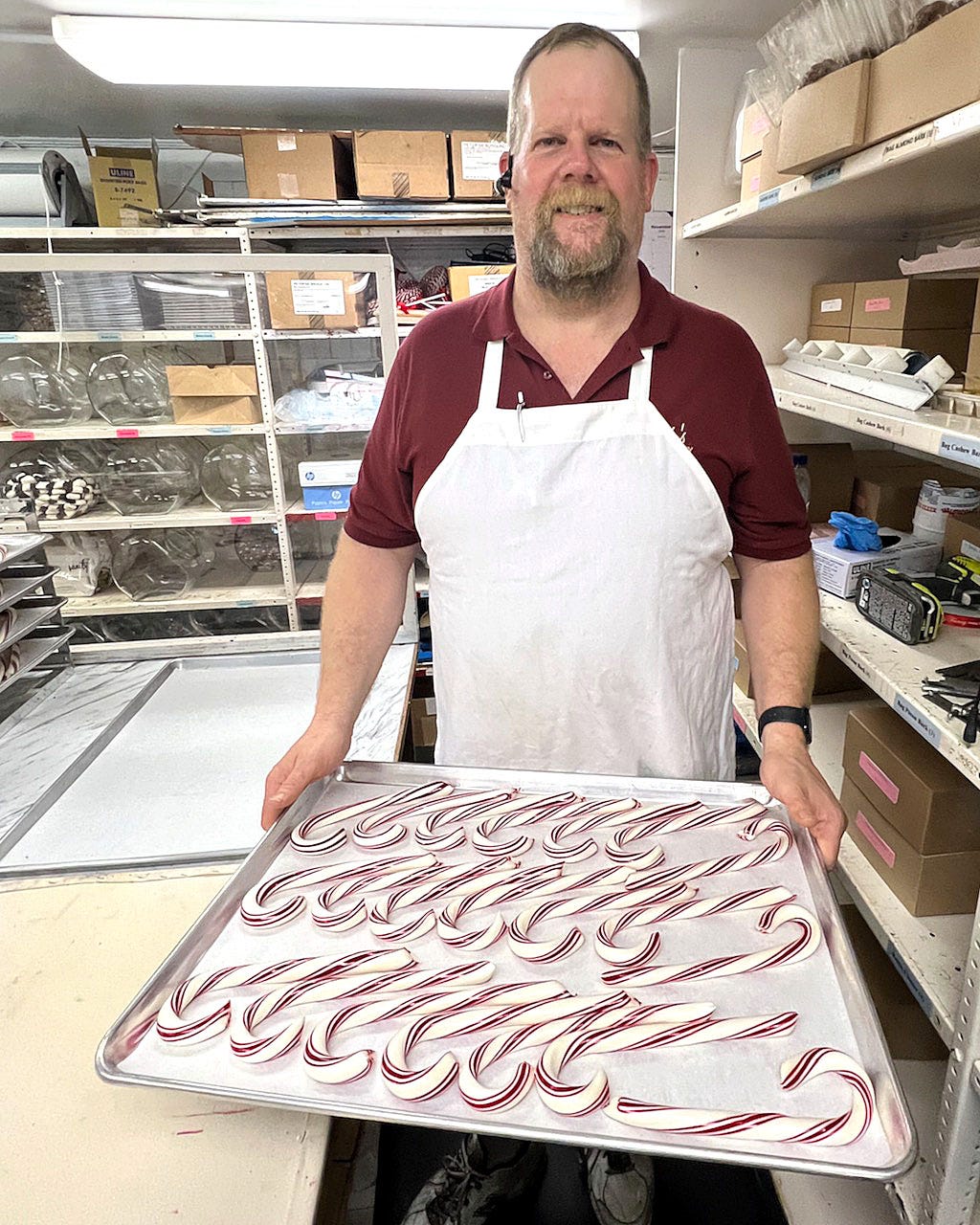 A person holding a tray of candy canes

Description automatically generated