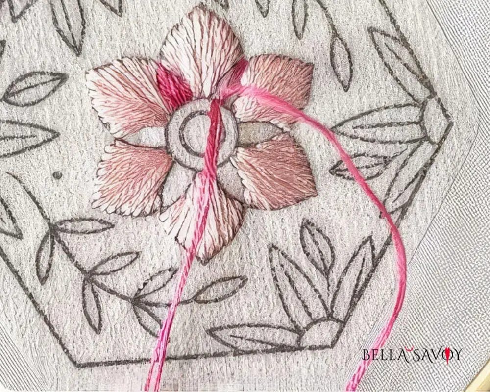 pink stitch being added to a floral stick and stitch pattern on fabric