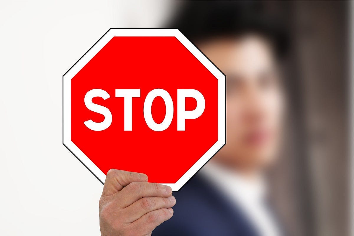 Blurry man holding a red/white STOP sign