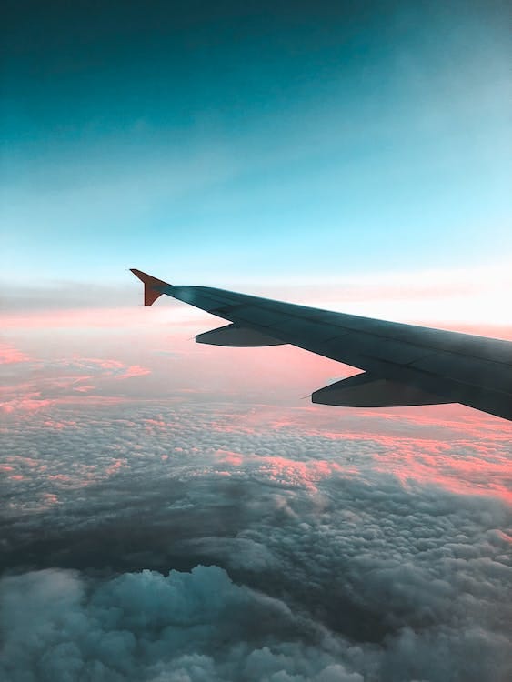 Free View of Airliner Wing Above the Clouds Stock Photo