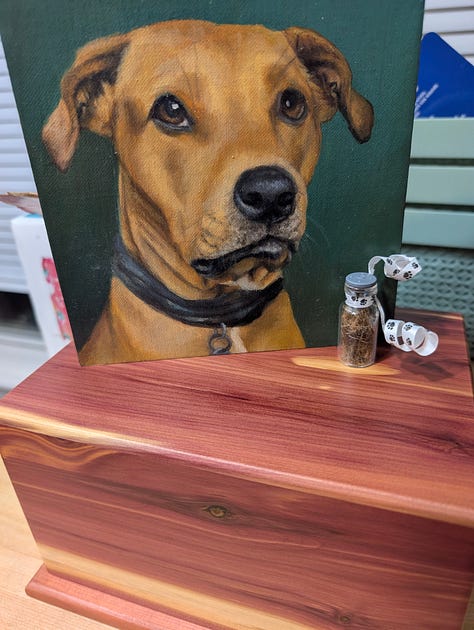 A memorial for Tali, with her ashes, portrait, flowers, and cards, paw prints, and other mementos.