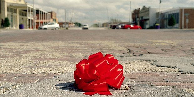 Red wrapping ribbon sits alone and aloof on the streets of Austin for Walker. Red wrapping ribbon sits alone and aloof on the streets of Austin for Walker.