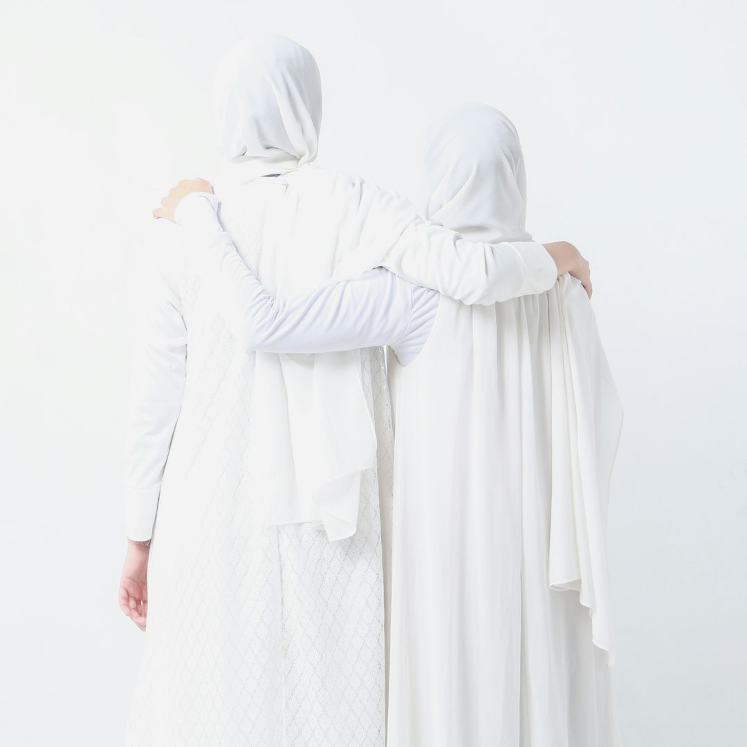 two women dressed in white standing next to each other