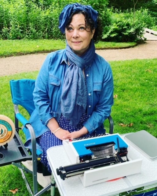 A dark-haired woman sits with a typewriter in a botanical garden, a freshly typed poem sits on a blue vintage trypewriter, a typewriter sits on a table on a rocky beach, a pink lotus flower blossoms in a lily pond