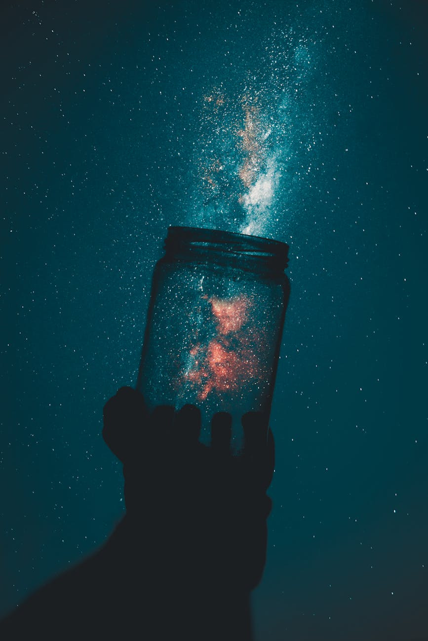 Photo by Rakicevic Nenad - creative photo of person holding glass mason jar under a starry sky