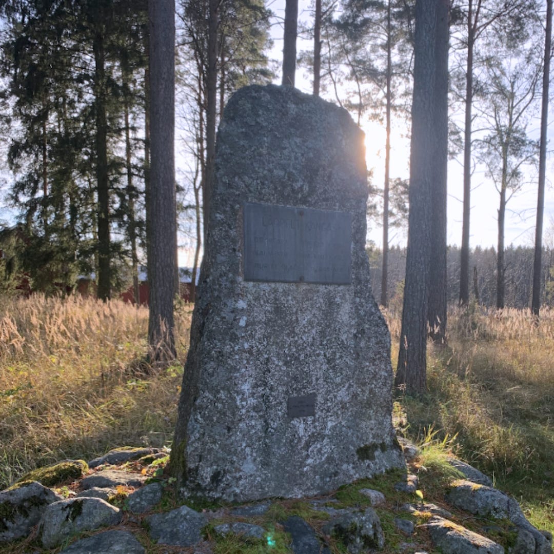 An image of a large stone with a metal plaque on it placed atop a small mound of stones and moss. Behind it is a pine forrest and the sun is glinting through the trees. Text on the plaque is not visible but indicates the marker of a Viking burial place used from 300-600AD An image of a large stone with a metal plaque on it placed atop a small mound of stones and moss. Behind it is a pine forrest and the sun is glinting through the trees. Text on the plaque is not visible but indicates the marker of a Viking burial place used from 300-600AD