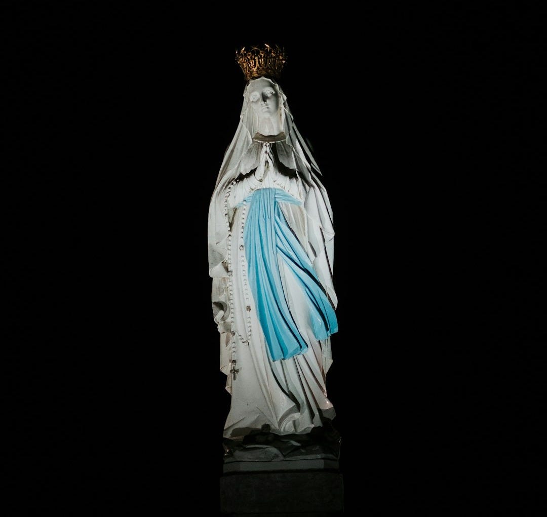 virgin mary statue on black surface