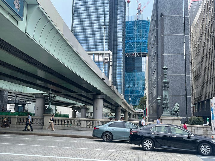 Four photographs of the bridge and the river beneath it, all of which are dominated by the expressway viaducts, which stand on thick concrete pillars dropped haphazardly into the river and fill almost its complete width, putting the bridge and river entirely into shade and blocking much of the sky.