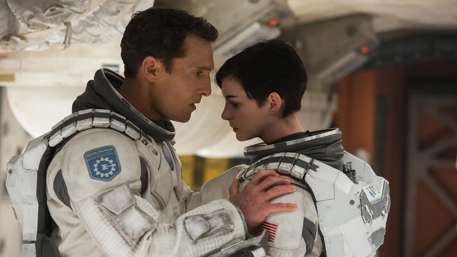 Interstellar | Still features Matthew McConaughey and Anne Hathaway in space outfits.