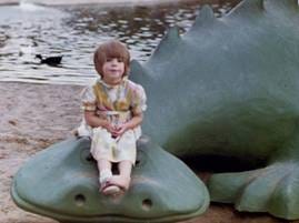 A child sitting on a statue of a crocodile

AI-generated content may be incorrect.