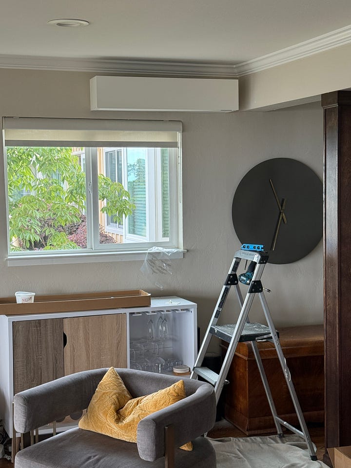A gallery of photos showing Quilt branded boxes, a worker, ladder, and tools, plus floor covering in the main room, and a photo of a wall showing a white mini-split above a bar cabinet.