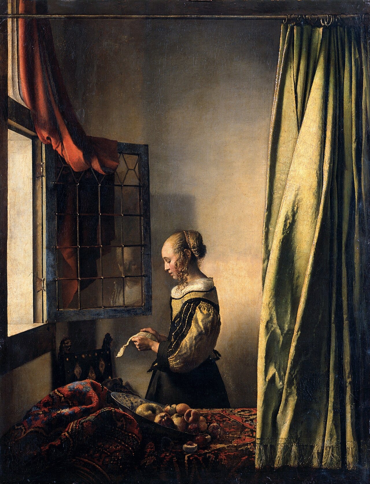 Woman reading a letter by an open window Woman reading a letter by an open window