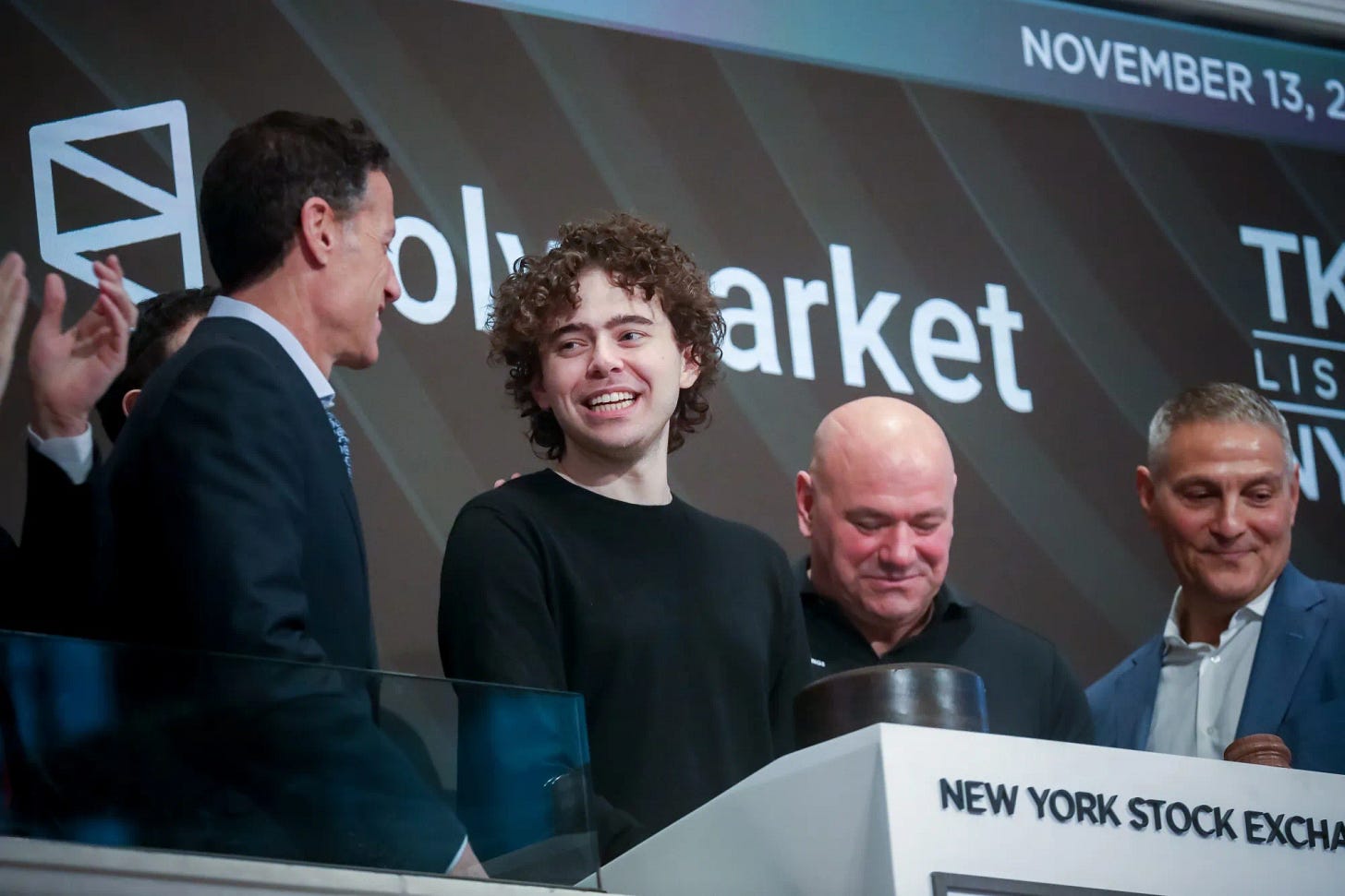 Polymarket Founder Shayne Coplan, center, rings the opening bell on the floor of the New York Stock Exchange on Nov. 13.