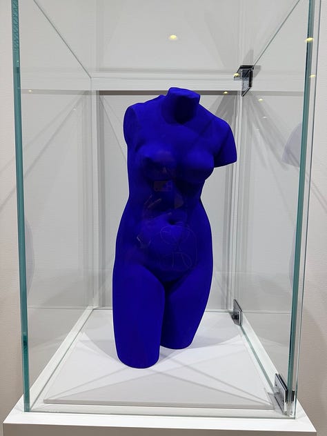 A grid of nine images depicting artworks by various artists, including Bruce Nauman, Jannis Kounellis, John Chamberlain, Yves Klein, Louise Nevelsen, Jenny Holzer, and Kan Yasuda.