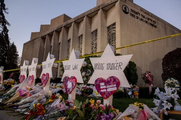 A memorial containing flowers and hearts outside a synagogue.