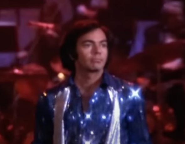 A person in a shiny blue shirt

Description automatically generated