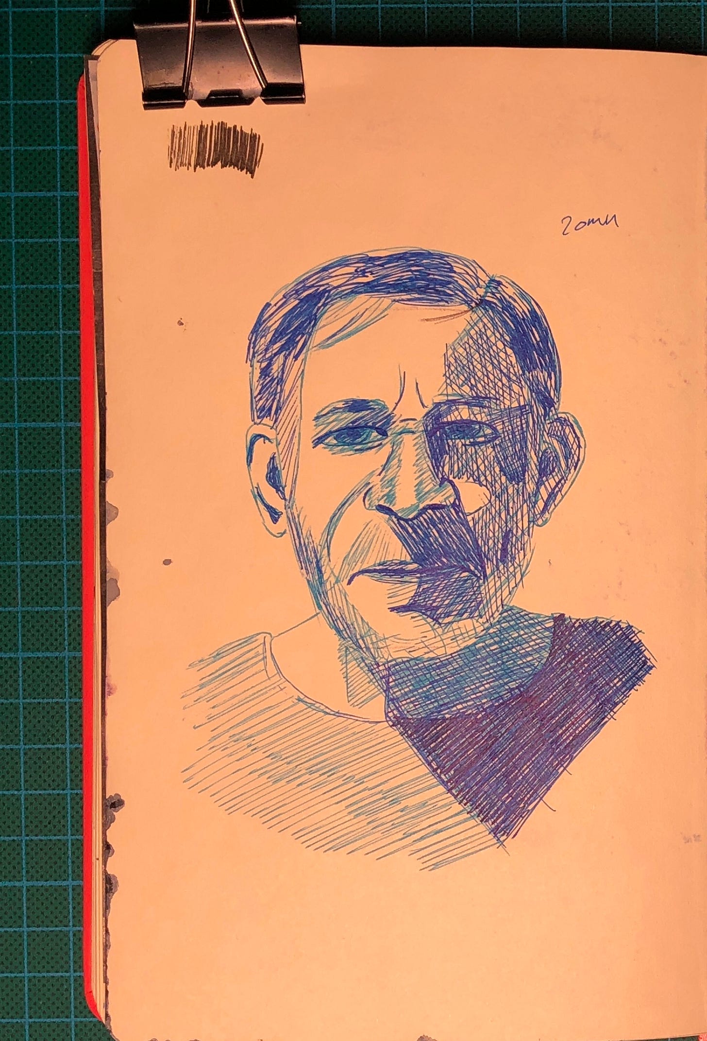 Photo d'une page de mon sketchbook où j'ai dessiné un portrait avec des stylos à bille de 3 valeurs de bleu différentes.