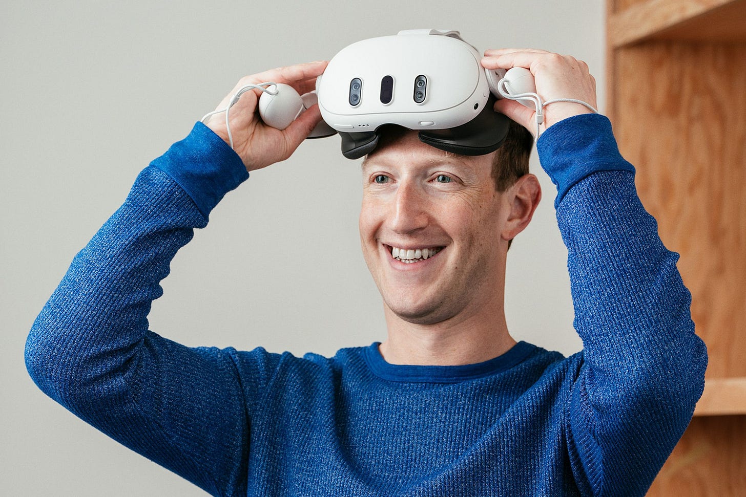 Mark Zuckerberg wearing the Meta Quest 3 headset and smiling.