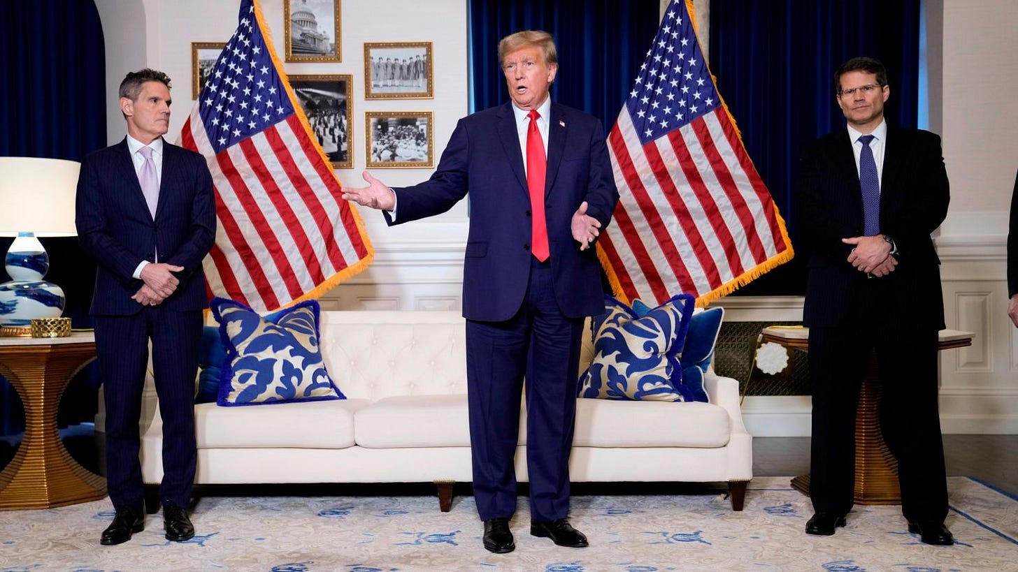 Former President Donald Trump speaks to the media at a Washington hotel, Tuesday, Jan. 9, 2024, after attending a hearing before the D.C. Circuit Court of Appeals at the federal courthouse in Washington, with attorneys John Lauro, left, and D. John Sauer, right.