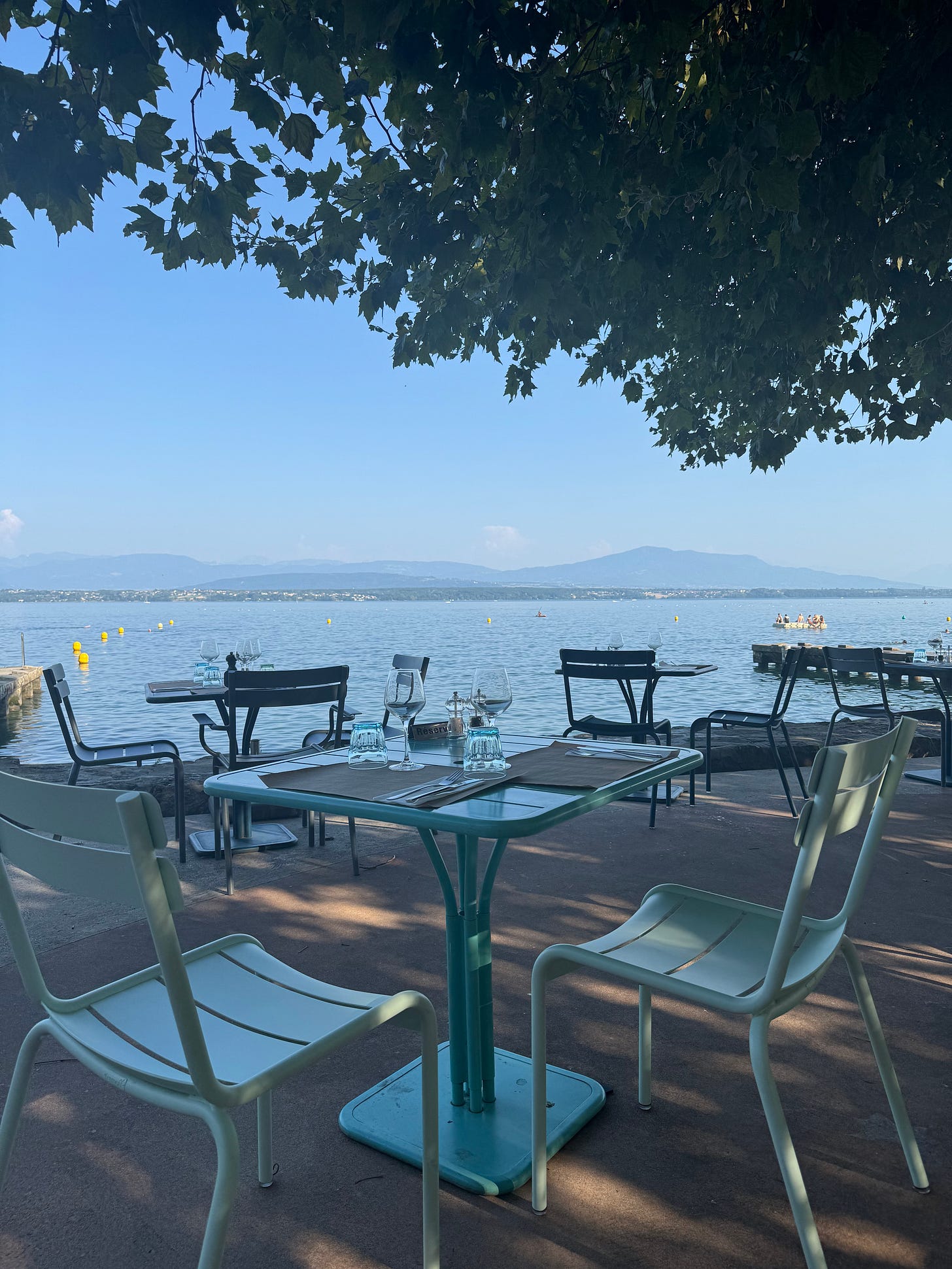 Tables and chairs in front of a lake