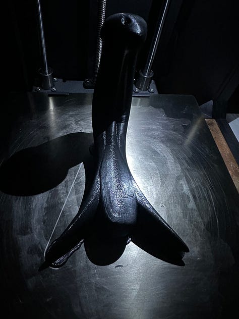 A custom 3D printer designed to look like solar punk, with black 3D printed anatomy models of reproductive organs.