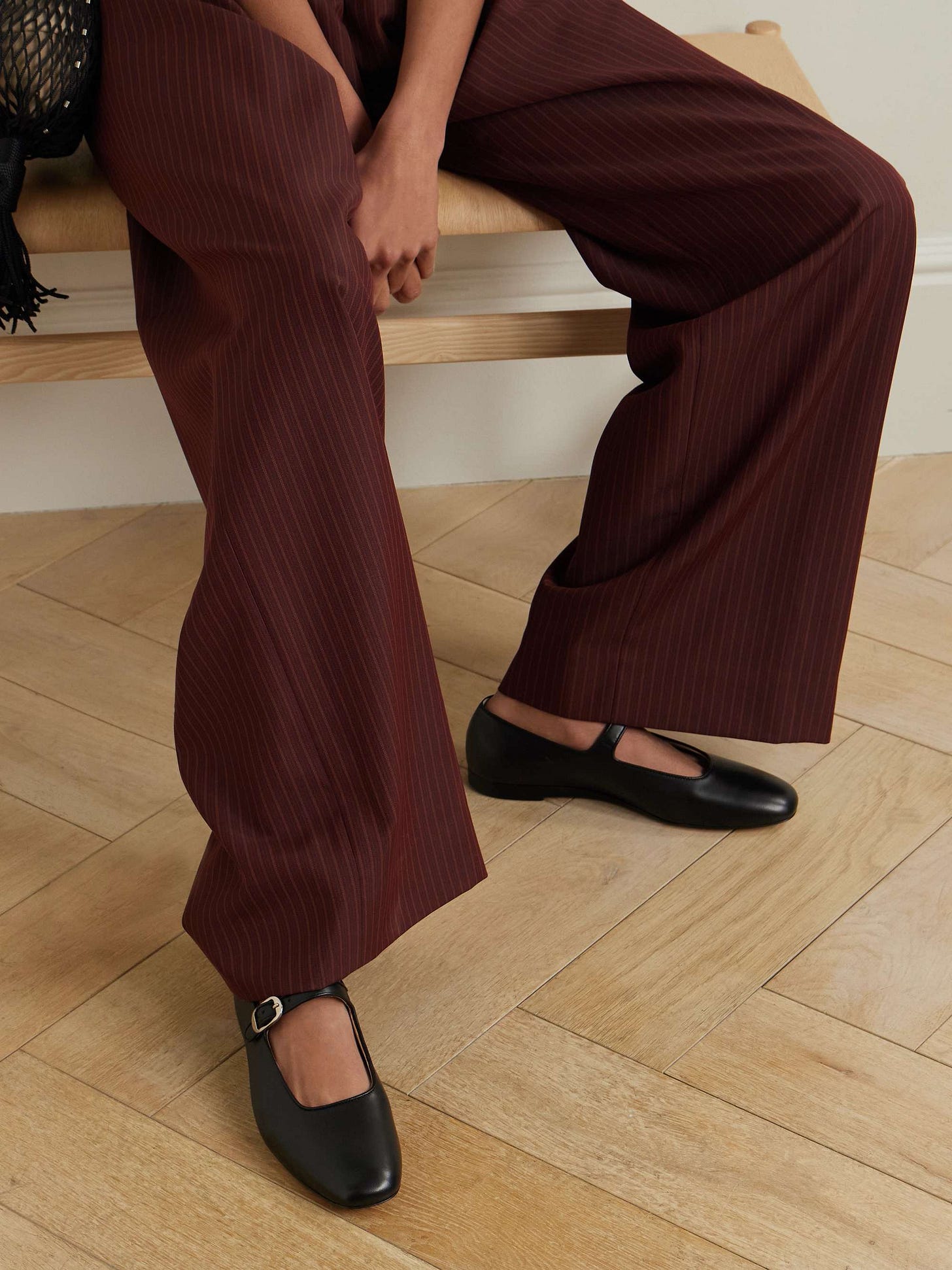 Woman wearing dark bugundy pants and Mary Jane shoes