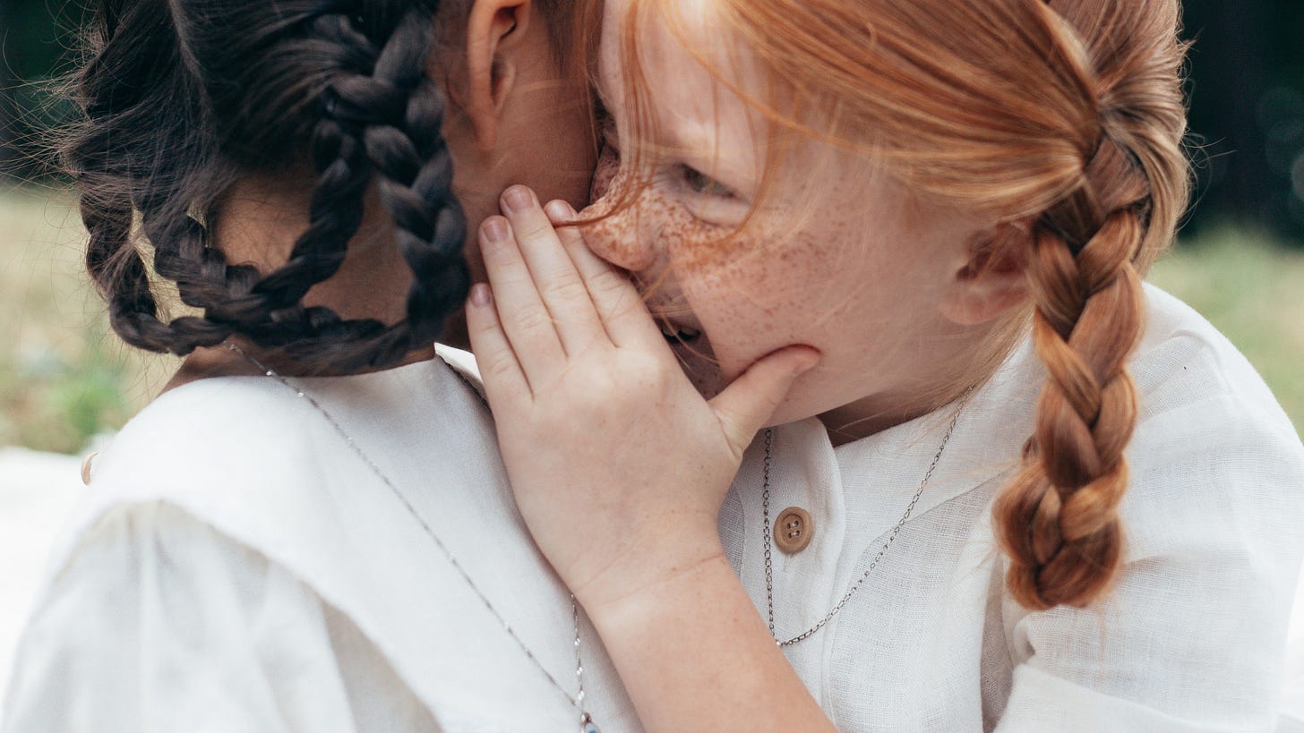 two girls telling secrets