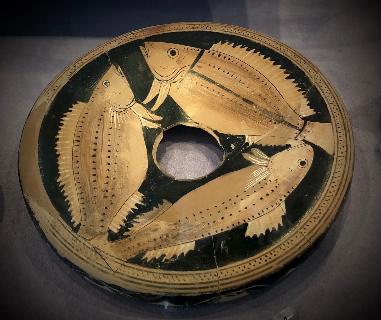 A circular object with fish on it

Description automatically generated