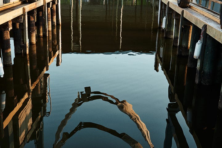 Yellow and blue-green color palette of water and a painted boat lift
