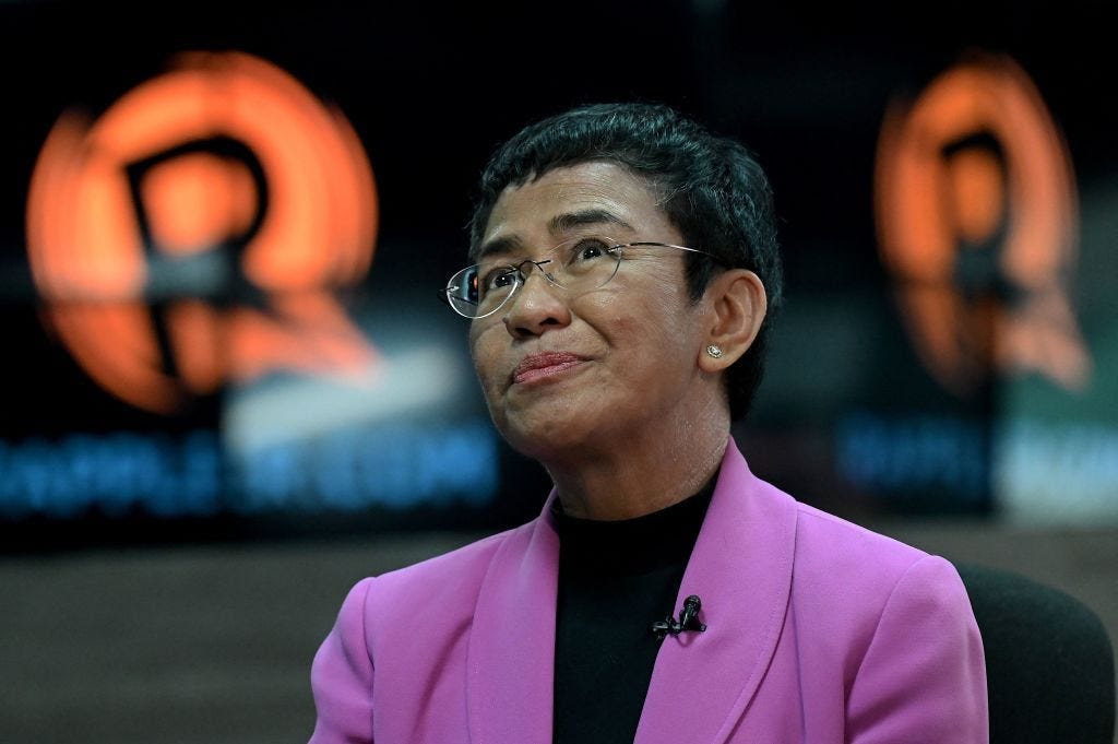 Portrait of Maria Ressa looking up, wearing a pink jacket Portrait of Maria Ressa looking up, wearing a pink jacket