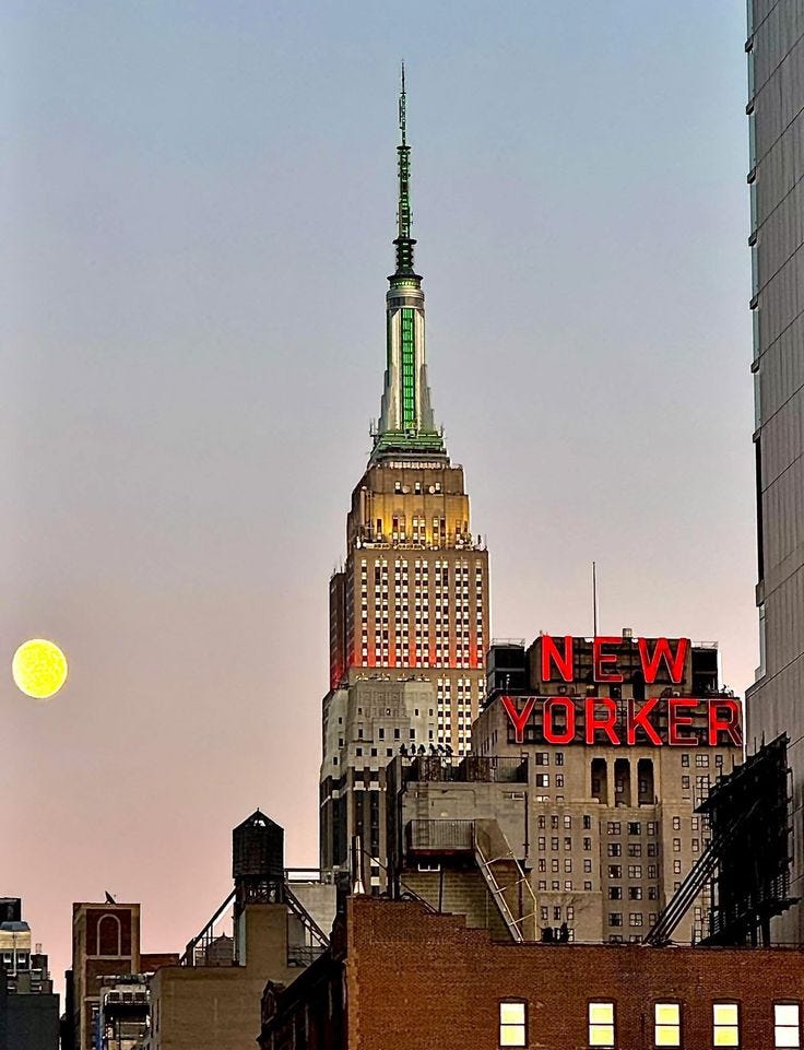 This may contain: the new york city skyline is lit up at night