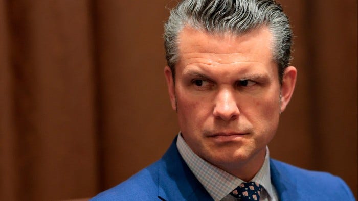Pete Hegseth looking to his right with a serious expression